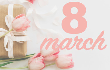 8 march. Happy womens day greeting card. 8 march text on pink tulips and gift box with ribbon on white background. Stylish tender image. Handwritten text, lettering