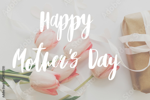 Happy mother's day.  Happy mother's day text and pink tulips with gift box on white background. Stylish soft image. Floral Greeting card. Happy Mothers day. Handwritten lettering