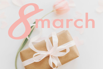 8 march. Happy womens day greeting card. 8 march text on pink tulip with gift box on white background, flat lay. Stylish tender image. Handwritten lettering. International women day