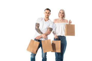 Fototapeta na wymiar smiling young tattooed couple with shopping bags isolated on white