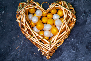 Golden heart with sweets on a black background.