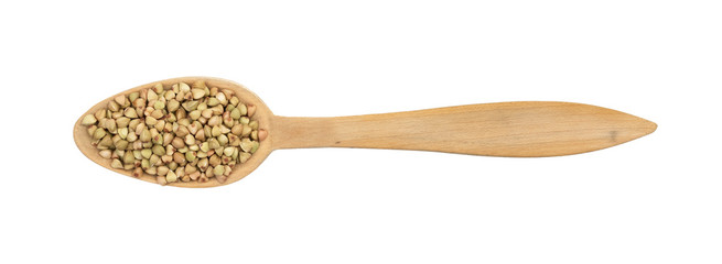 Green buckwheat on a wood spoon seen directly from above and isolated on white background