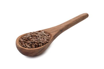 Linseeds or flax seed on a brown wooden spoon seen obliquely from the front and above and isolated on white background
