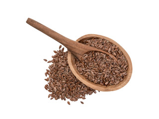Linseeds or flax seed in a small oval wooden bowl with a spoon and pile next to it seen directly from above and isolated on white background