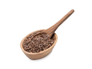 Linseeds or flax seed in a small oval wooden bowl with a spoon seen obliquely from front and above and isolated on white background