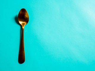 yellow metal spoons imitating gold on a blue background