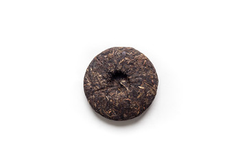 Little cake of Chinese Shou Pu-erh tea on a white background