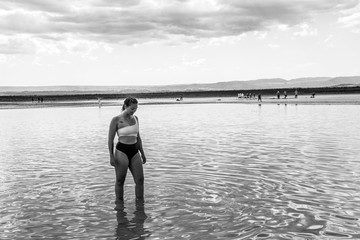 a woman walking through the reflection of water