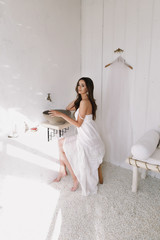 Naklejka premium Portrait of a young beautiful woman. Bride in elegant classic wedding dress. Morning of the bride. Wedding preparations.