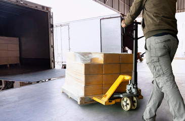Workers Using Hand Pallet Jack Unloading Package Boxes into Cargo Container. Delivery Shipment...