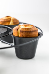 A close up view of a popover in the pan fresh out of the oven. 