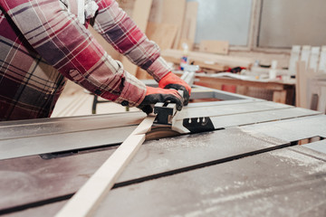 Carpenter cuts plywood on a circular saw