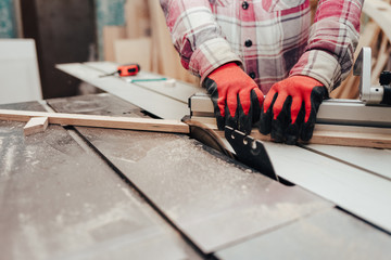 Carpenter cuts plywood on a circular saw