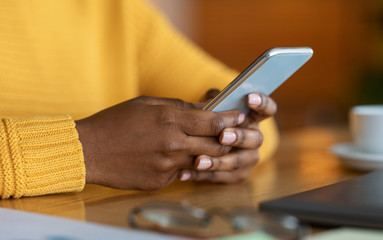 Fototapeta premium Hands of black woman holding modern smartphone