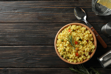 Composition with bowl of delicious rice on wooden background, top view