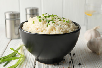 Composition with bowl of delicious rice on wooden background, closeup