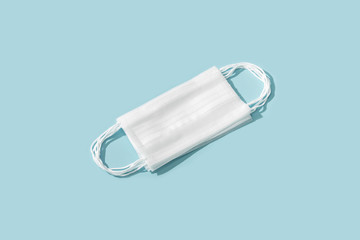 Flat lay composition with protective white face mask on color background