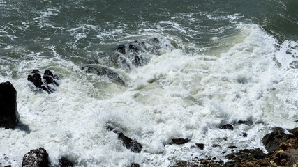 Ocean waves crashes on the rocks, windy weather on ocean.