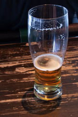 Half empty mug during drinking beer in a bar on wooden table