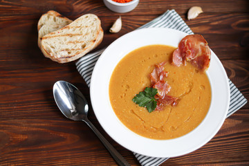 Vegetable soup with lentils on a wooden background. Served with chopped cherry tomatoes and herbs. Nearby are pieces of ciabatta. Raw groats in the background. Vegetarian dish.