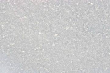 The texture of freshly fallen snow. Christmas template for design. Clearly visible individual snowflakes. Winter background.