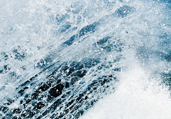 Strong wave with foam and ripple splash water texture in a summer sea, ocean or river.