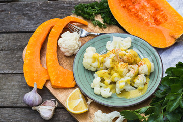 Steamed cauliflower with sauce and pumpkin and greenery