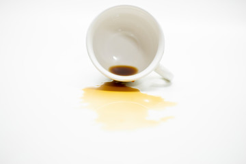Coffee spilled from a cup stained on the white desk surface