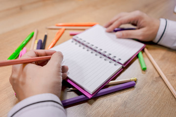 A human are writing document on the work table.