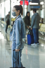 Woman wearing protective mask in airport, Coronavirus contagion fears concept