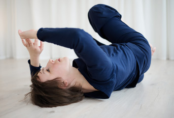 Woman lies on the floor and practices bodily practice in the gym.