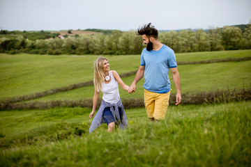 Fototapeta premium Loving couple enjoying a walk through grass land
