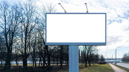 Obraz premium Advertising billboard metal, large horizontal. Behind a park with trees. With white margin for mock-up posters