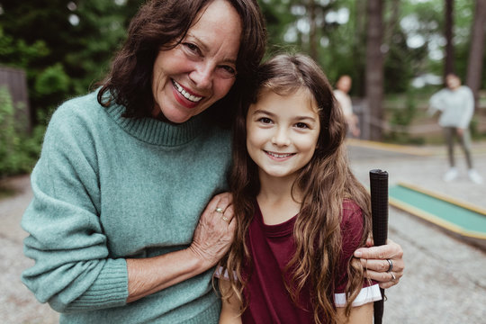 Portrait of smiling grandmother with granddaughter standing outdoors