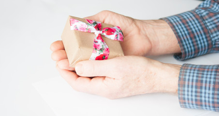 Elderly hands are holding a gift.