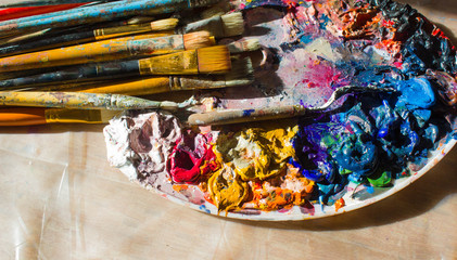Workplace painter palette with colors and brushes. Palette of colors, creative disorder, art.
