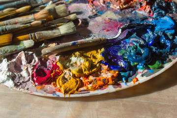 Workplace painter palette with colors and brushes. Palette of colors, creative disorder, art.