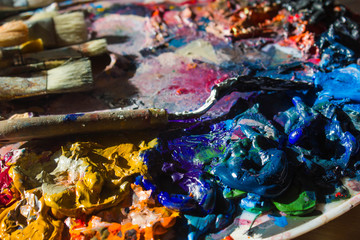 Workplace painter palette with colors and brushes. Palette of colors, creative disorder, art.