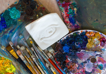 Workplace painter palette with colors and brushes. Palette of colors, creative disorder, art.