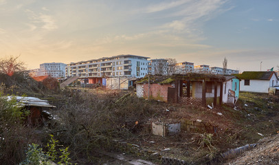 Fototapeta na wymiar Ruins of huts in front of modern buildings