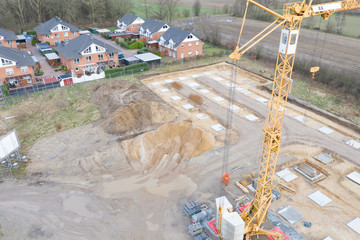 Drone image of a large construction site on which the concrete foundation for the columns of a factory building is being cast