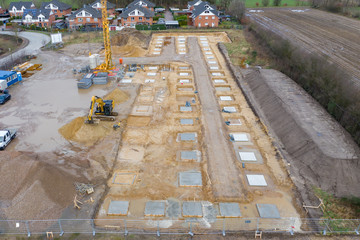 Drone image of a large construction site on which the concrete foundation for the columns of a...