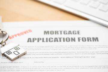 Approved mortgage loan agreement application with house shaped keyring
