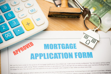 Approved mortgage loan agreement application with house shaped keyring