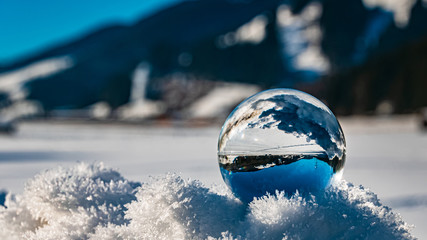 Crystal ball on snow crystals alpine winter landscape shot at Flachau, Salzburg, Austria