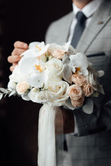 Groom with wedding bouquet. Morning of the groom. Groom morning preparation. 