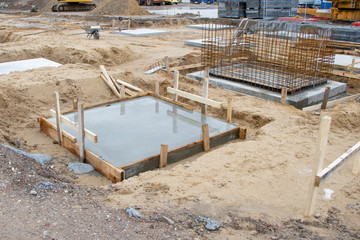 Fototapeta na wymiar concrete foundations for the columns of a factory building are poured on a large construction site