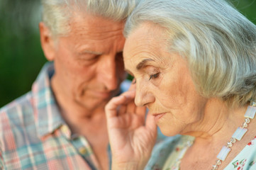 Close up portrait of unhappy senior couple in the park