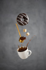a cup of coffee with a splash freezes in the air a coffee spoon hovering in the air pours out...
