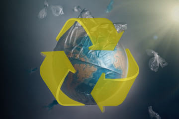 Globe of planet Earth in a garbage bag. Yellow recycling sign. The concept of conservation of the...